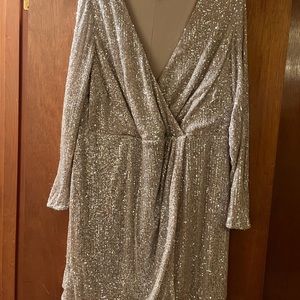 Faux wrapped sequin dress with nude background. Sequins appear to be silvery.